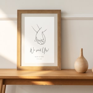 Peut inclure: Un dessin au trait noir et blanc de deux mains se tenant l'une l'autre. Le texte "We said Yes!" est sous le dessin, suivi de "Julia & Sera" et "01.30.2023".