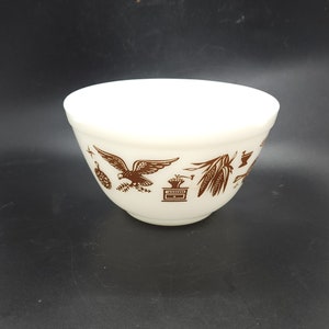May include: White mixing bowl with a brown eagle, corn, and other designs.