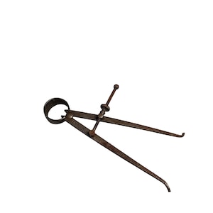 May include: An antique rusty metal caliper tool with curved tips and a circular handle. The tool has a screw adjustment and is designed for measuring. The caliper is set against a white background.