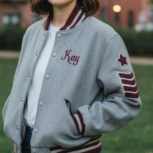 May include: A white ceramic mug with a black handle and the text "But First, Coffee" in a black, handwritten-style font. The mug is on a white surface.