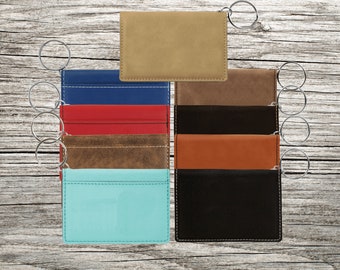 May include: Assortment of eight keychains in various colors and materials, including brown leather, blue leather, red leather, and turquoise leather. Each keychain has a silver key ring.