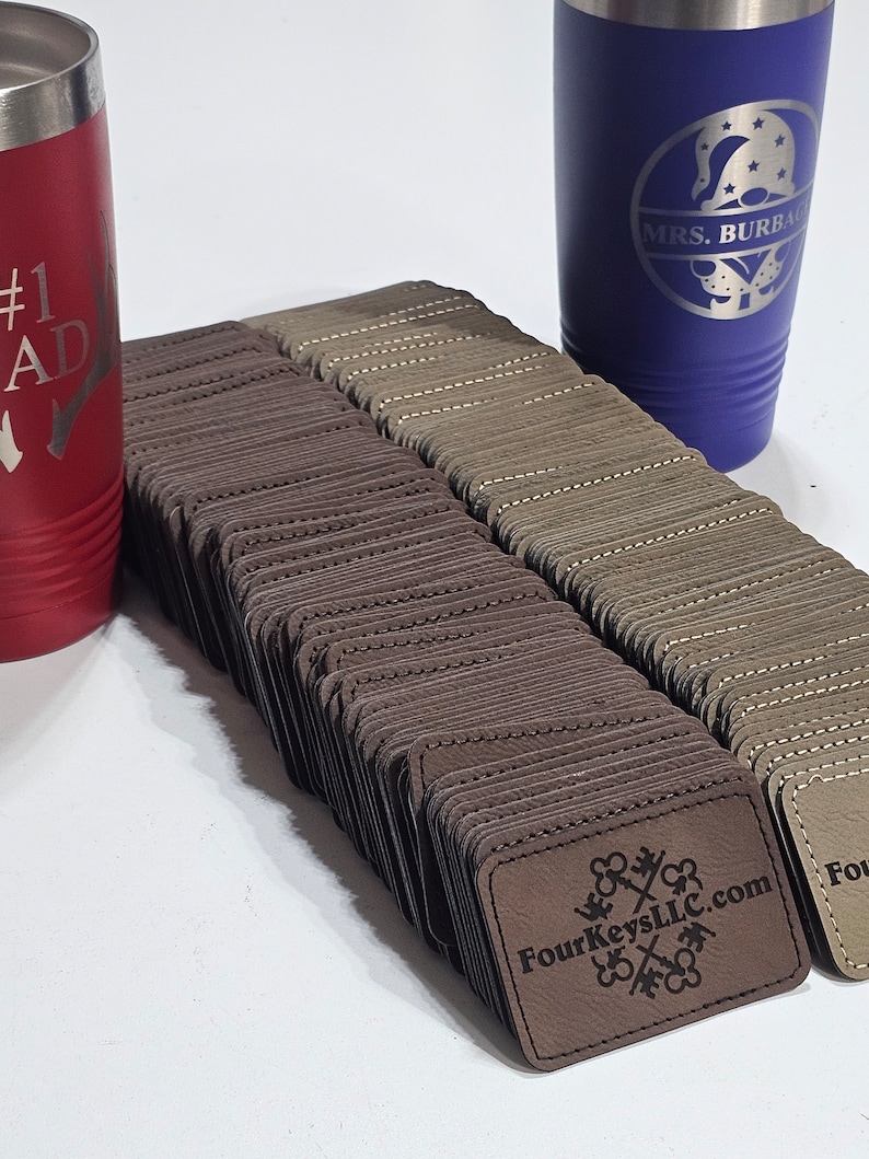 May include: A stack of brown leather labels with the text "FourKeysLLC.com" and a logo of four keys intertwined. The labels are stacked on a white surface.