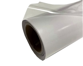 May include: A roll of white vinyl adhesive backed film. The film is rolled up on a cardboard core.