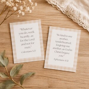 May include: Two rectangular cards with text on a wooden surface. The cards have a beige and white checkered border. One card reads "Whatever you do, work heartily, as for the Lord and not for men." Colossians 3:23. The other card reads "Be kind to one another, tenderhearted, forgiving one another, as God in Christ forgave you." Ephesians 4:32.