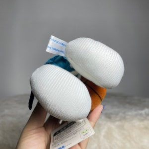 K&ouml;nnte beinhalten: Ein Pl&uuml;sch-Basketballspieler, der ein blaues Trikot und wei&szlig;e Shorts tr&auml;gt. Das Spielzeug h&auml;lt einen Basketball und hat ein wei&szlig;es gesticktes Design an seinen F&uuml;&szlig;en. Das Spielzeug hat ein Etikett mit japanischem Text.