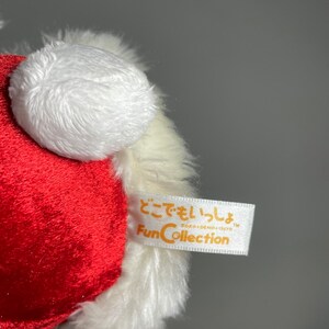May include: Red and white plush toy with a white pom-pom on top. The toy has a white tag with the text "どこでもいっしょ DOKI-DOKI-ISSYO TM FunCollection" in Japanese.