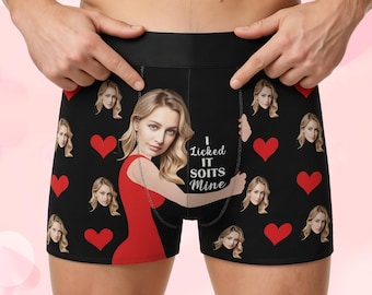 May include: Black boxer briefs with a repeating pattern of red hearts and a woman's face. The front features a large image of the woman in a red dress, with the text "I Licked IT SOITS Mine."