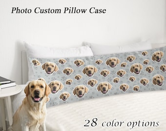 May include: A custom body pillow case featuring a repeating pattern of a dog's face and paw prints on a light gray background. The text "Photo Custom Pillow Case" is at the top, and "28 color options" is at the bottom.