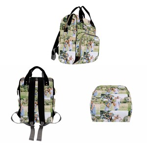 May include: A black diaper bag with a photo collage of a family on a green grassy field. The bag has a large main compartment and a smaller front pocket. The bag also has adjustable straps and a handle.