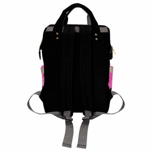 May include: Black canvas backpack with gray straps and a pink zippered pocket. The backpack has a top handle and adjustable straps.