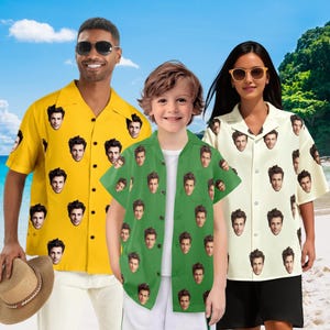 May include: Three people wearing custom Hawaiian shirts with a repeating face pattern. The shirts are yellow, green, and off-white. The background shows a beach scene with blue sky and ocean.