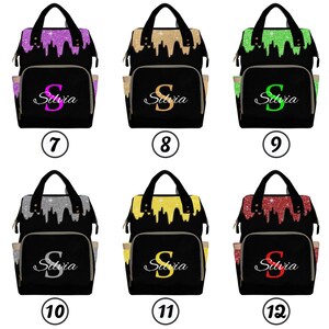 May include: Six black diaper bags with different glitter colors on the front. The bags have a gold zipper and a gold handle. The name "Silvia" is written on the front of each bag.