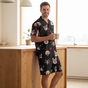 K&ouml;nnte beinhalten: Schwarzes Pyjama-Set mit verschiedenen Hunderassen und roten Herzen. Das kurz&auml;rmelige Hemd und die Shorts sind aus weichem Material. Ein bequemes Schlafanzug-Set f&uuml;r Hundeliebhaber.