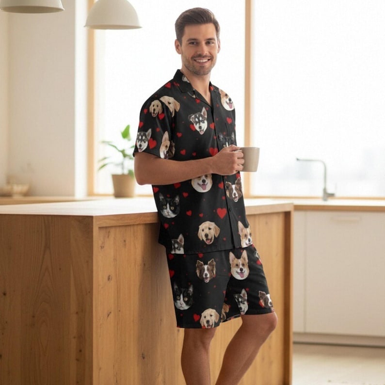 K&ouml;nnte beinhalten: Schwarzes Pyjama-Set mit verschiedenen Hunderassen und roten Herzen. Das kurz&auml;rmelige Hemd und die Shorts sind aus weichem Material. Ein bequemes Schlafanzug-Set f&uuml;r Hundeliebhaber.