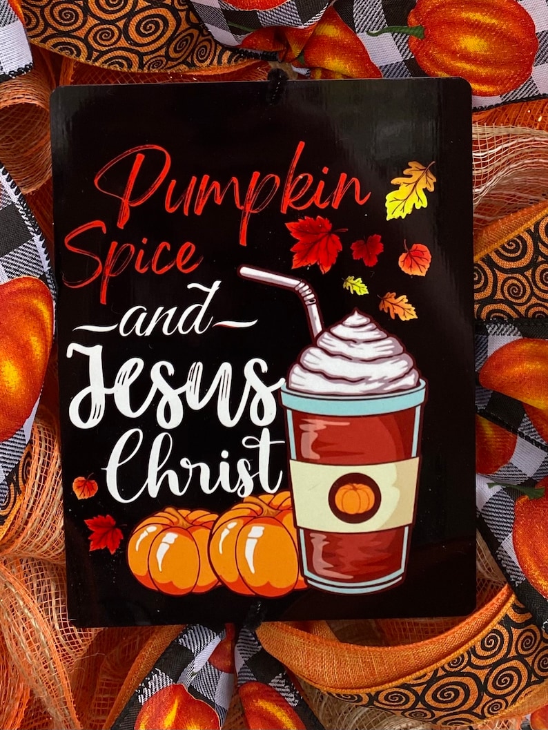 Pu&ograve; includere: Un cartello nero con testo bianco che recita "Pumpkin Spice and Jesus Christ". Il cartello presenta un'immagine di cartone animato di un latte alla zucca speziato con panna montata e una cannuccia.