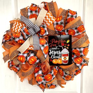 Pu&ograve; includere: Una ghirlanda autunnale con nastro a quadri arancio e nero, nastro a spirale arancio e marrone e un cartello che recita "Pumpkin Spice and Jesus Christ".