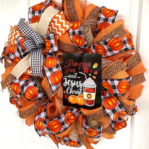 Pu&ograve; includere: Una ghirlanda autunnale con nastro a quadri arancio e nero, nastro arancio con motivo a spirale e un cartello che recita "Pumpkin Spice and Jesus Christ".