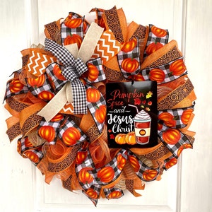 Pu&ograve; includere: Una ghirlanda autunnale con nastro a quadri arancio e nero, nastro a spirale arancio e marrone e un cartello che recita "Pumpkin Spice and Jesus Christ".
