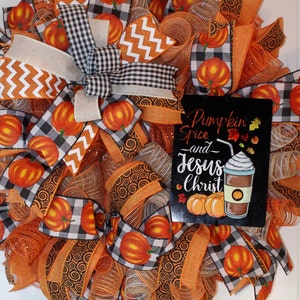 Pu&ograve; includere: Una ghirlanda autunnale con nastro a quadri arancio e bianco, nastro a chevron arancio e bianco e nastro a spirale arancio. La ghirlanda presenta anche un cartello con la scritta "Pumpkin Spice and Jesus Christ" con un disegno di una tazza di caff&egrave; con panna montata.