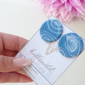 Könnte beinhalten: Ein Paar blaue und weiße Ohrringe mit Wirbelmuster auf einer weißen Karte mit dem Text "hallso wild jewellery" und "wild_jewelry hallso wild.etsy.com".