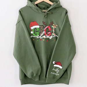 Custom Christmas Gigi Claus Grandma Sweatshirt With Grandkids On Sleeve Gift For Christmas, Personalized Sweatshirt  Gift For Nana Gigi,