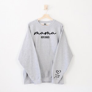 May include: Gray sweatshirt with the text "mama EST. 2023" on the front and a heart with the text "mary jane" on the sleeve.