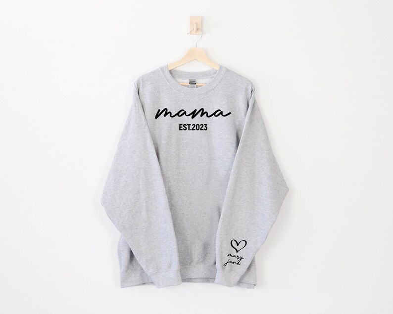 May include: Gray sweatshirt with the text "mama EST. 2023" on the front and a heart with the text "mary jane" on the sleeve.