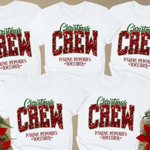 May include: White t-shirts with the text "Christmas CREW" in red glitter lettering and green script. The phrase "MAKING MEMORIES =TOGETHER=" is below the word "CREW". The shirts are arranged in a group.