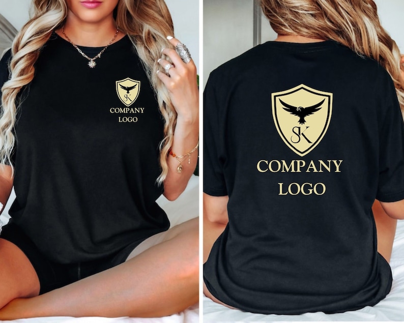 May include: Black t-shirt with a gold shield logo featuring a stylised eagle and the letters "SK" inside the shield. The text "COMPANY LOGO" is printed below the shield.