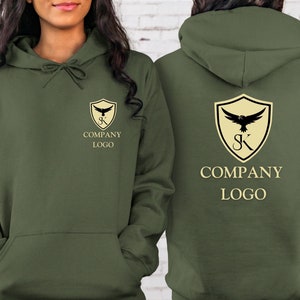 May include: Two olive green hoodies with a company logo featuring a shield with a bird and the letters "SK" inside. The text "COMPANY LOGO" is printed below the shield.