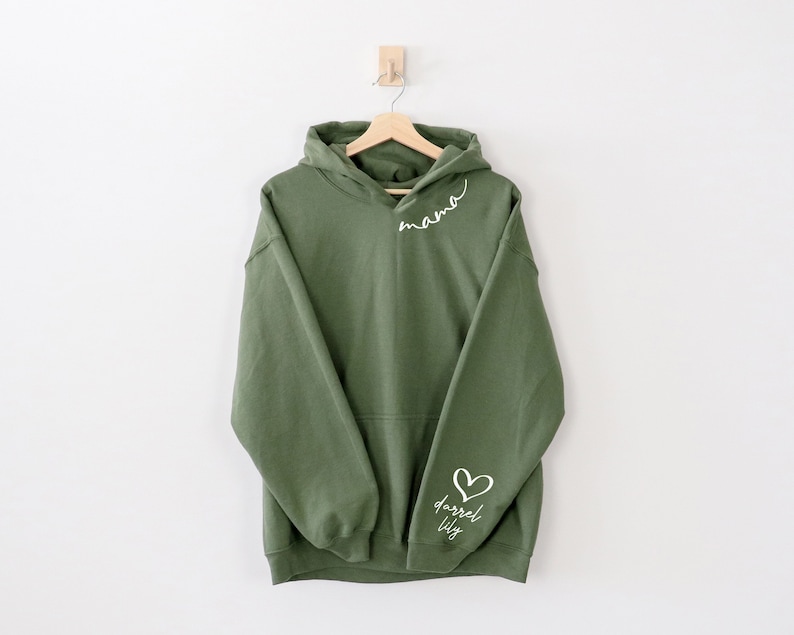 May include: A green hooded sweatshirt with the word "mama" written on the front and a heart with the words "darrel lily" on the sleeve.