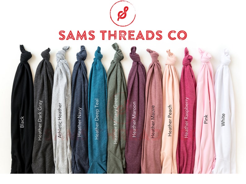 May include: A display of folded t-shirts in various colors, including black, gray, navy, teal, and pink. The shirts are labeled with their color names, such as "Black" and "Heather Navy." The brand name "SAMS THREADS CO" is displayed at the top.