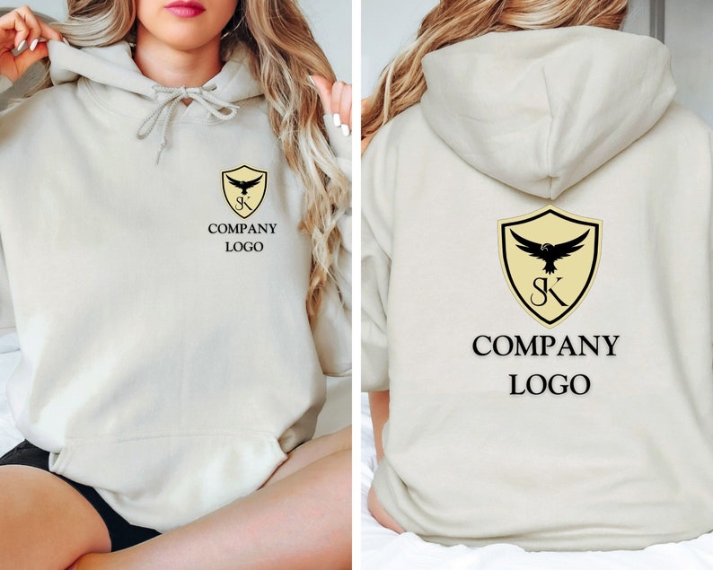 May include: A beige hoodie with a black and yellow logo on the front and back. The logo is a shield with a bird inside and the letters "SK" below. The text "COMPANY LOGO" is below the shield.