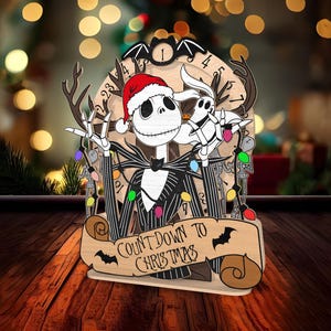 May include: A wooden Christmas countdown ornament featuring Jack Skellington from The Nightmare Before Christmas wearing a Santa hat and holding a Christmas light. The ornament has a scroll with the text "Count Down to Christmas".