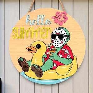 May include: Round wooden sign with the words "hello summer" in blue and yellow. The sign features a cartoon character wearing sunglasses and a hockey mask, relaxing on a yellow inflatable duck. A pink hibiscus flower is on the top right.