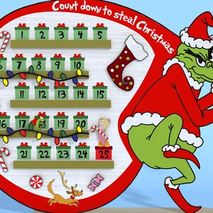 Puede incluir: Un calendario de adviento de madera con el Grinch, un personaje verde con un gorro de Pap&aacute; Noel rojo, sosteniendo una bolsa. El calendario tiene 25 casillas numeradas, cada una con una peque&ntilde;a imagen de caja de regalo. El texto "Count down to steal Christmas" est&aacute; escrito en un arco rojo sobre el calendario.