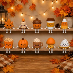 Könnte beinhalten: Eine Sammlung von zehn kleinen, anthropomorphen Herbstfiguren, die auf zwei Holzregalen angeordnet sind. Die Figuren stellen ein Ahornblatt, eine Kerze, eine Eichel, einen Kaffeebecher, ein Zuckermais-Bonbon, einen Popcorn-Eimer, einen Kürbis, eine Kakaotasse, einen Pilz und ein Stück Kuchen dar.