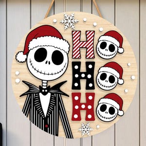 May include: Round wooden Christmas sign featuring Jack Skellington in a Santa hat, with the words "HO HO HO" and Jack Skellington faces wearing Santa hats. The sign is light brown with white, black, and red accents, and a jute rope for hanging.