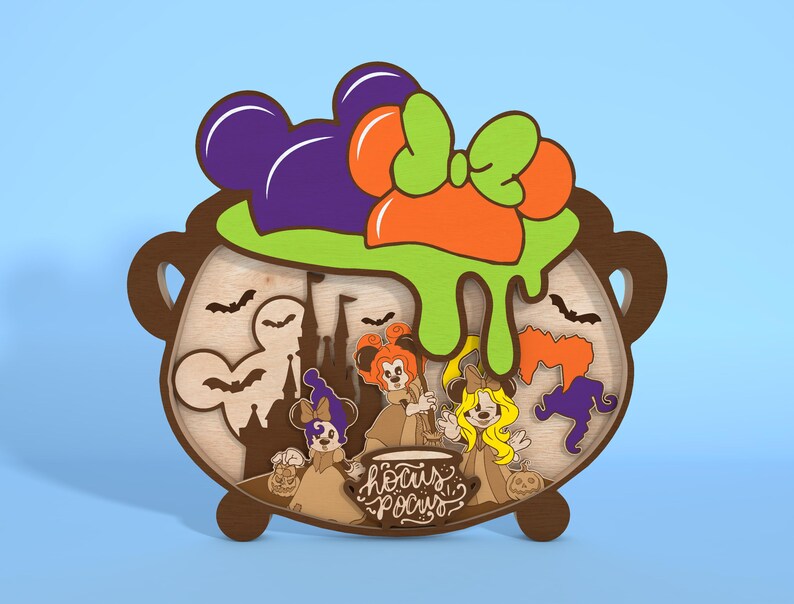 May include: Wooden Halloween decoration featuring a cauldron with Mickey Mouse ears, a green and orange bow, and the text "Hocus Pocus." The cauldron contains silhouettes of bats, a castle, and three witch characters. The color scheme includes brown, purple, orange, and green.