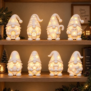Puede incluir: Ocho figuras de gnomos de cerámica blanca dispuestas en dos estantes de madera. Cada gnomo presenta patrones recortados de estrellas y copos de nieve que brillan con una luz cálida. Sostienen varios objetos festivos como una linterna y un regalo.