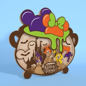May include: A wooden Halloween decoration featuring a cauldron design with a purple Mickey Mouse ear hat, orange bow, and green slime. The cauldron has a layered design with bats, a castle, and cartoon characters. The text "Hocus Pocus" is also included.