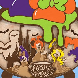 May include: A wooden Halloween-themed decoration featuring a cauldron with green slime and the text "Hocus Pocus." The design includes cartoon characters, bats, a castle, and pumpkins. The cauldron is brown with a light wood interior.