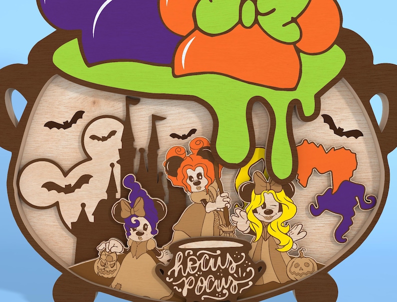 May include: A wooden Halloween-themed decoration featuring a cauldron with green slime and the text "Hocus Pocus." The design includes cartoon characters, bats, a castle, and pumpkins. The cauldron is brown with a light wood interior.
