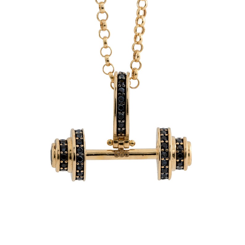 Op de afbeelding: Een gouden ketting met een halter hanger. De halter is bezet met zwarte edelstenen.
