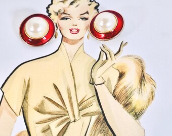 May include: Illustration of a woman wearing large, round earrings. The earrings have a red border with a white pearl center. The woman is wearing a light yellow dress and holding a fur stole.