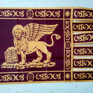 May include: A maroon flag with a gold winged lion holding a book with the text "PAX TIBI MAR STA CE MEVS". The lion is standing on a gold platform. The flag has a gold border with a repeating pattern of circles and swirls.