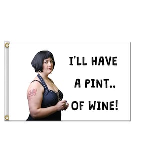 May include: A white flag with a woman with black hair and a black tank top with a dragon tattoo on her arm. The text on the flag reads "I'll have a pint... of wine!"