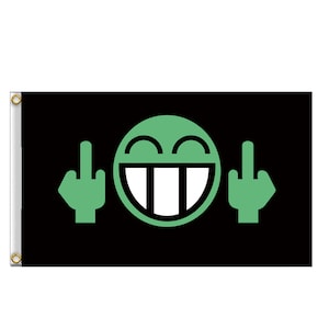 Può includere: Una bandiera nera con un'emoticon verde che fa il dito medio su entrambi i lati. L'emoticon ha un ampio sorriso e denti grandi.