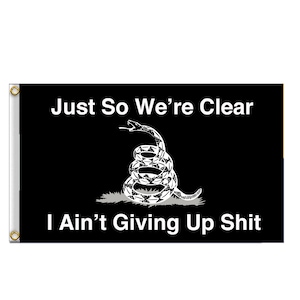 May include: Black and white flag with a coiled snake and the text "Just So We're Clear I Ain't Giving Up Shit".