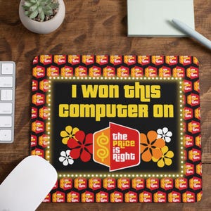 May include: A rectangular mousepad with the text "I WON THIS COMPUTER ON THE PRICE IS RIGHT". The mousepad has a black background with yellow text and a border of lights. The Price is Right logo is in the center.